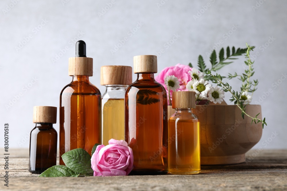 Aromatherapy. Different essential oils and flowers on wooden table