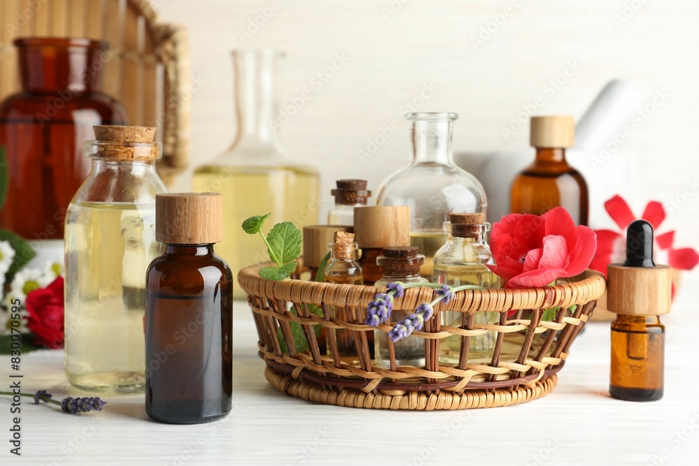 Aromatherapy. Different essential oils and flowers on white wooden table Aromatherapy. Different essential oils and flowers on white wooden table