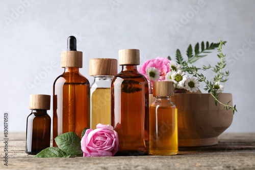 Aromatherapy. Different essential oils and flowers on wooden table