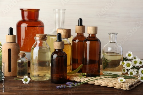 Aromatherapy. Different essential oils and flowers on wooden table