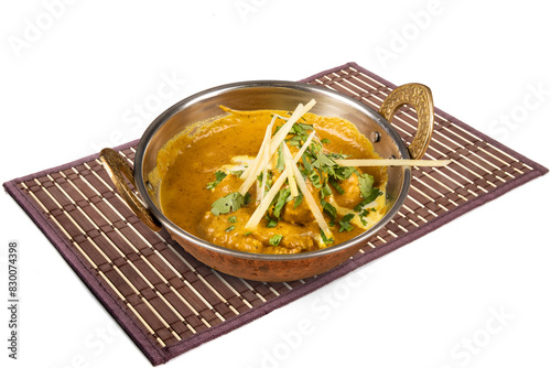 A traditional copper serving bowl filled with the Indian dish Malai Gobi, cauliflower curry, isolated on white photo