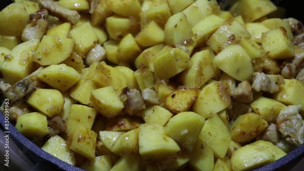 Fried potatoes with meat close-up in a frying pan Fried potatoes with meat close-up in a frying pan