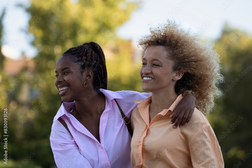 Side view portrait of multiethnic friends girls enjoying time together in a park Side view portrait of multiethnic friends girls enjoying time together in a park