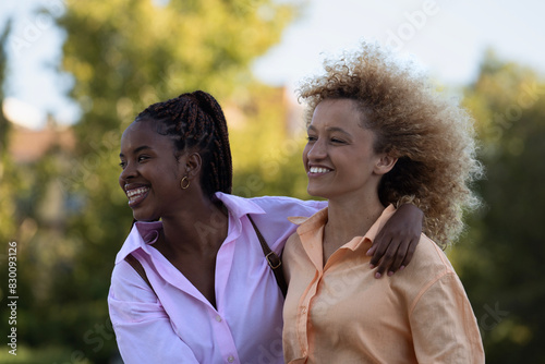 Side view portrait of multiethnic friends girls enjoying time together in a park