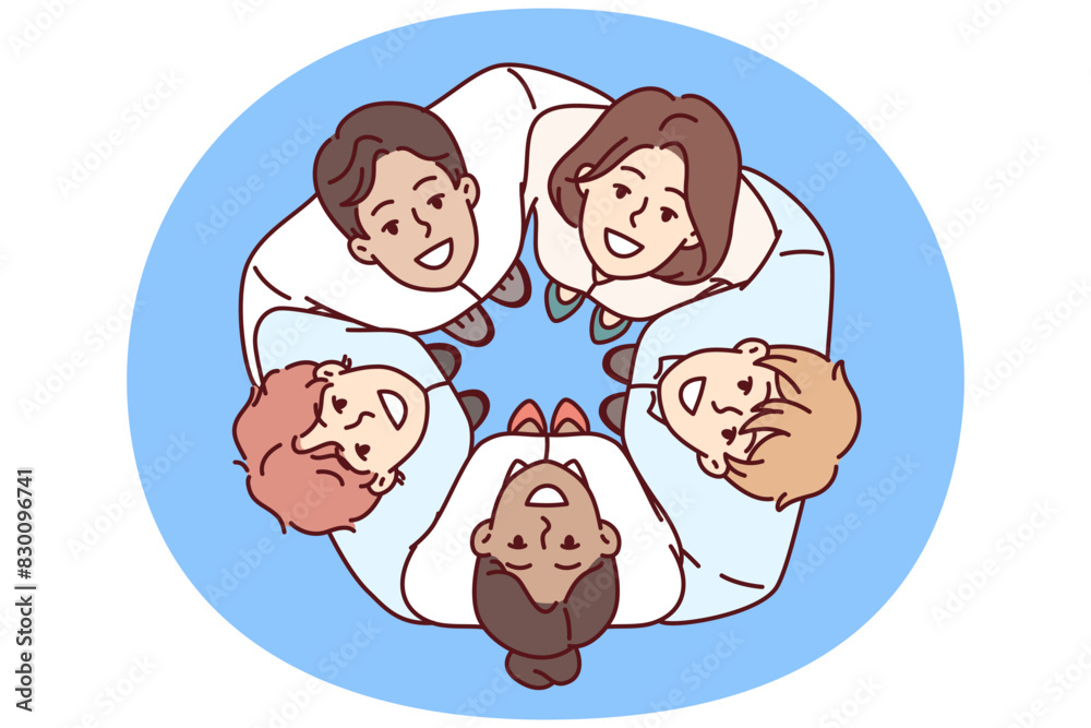 Team of young diverse businesspeople stand in circle and hugging colleagues look up during team building. Happy businesspeople take pride in teamwork or being part of big corporation Team of young diverse businesspeople stand in circle and hugging colleagues look up during team building. Happy businesspeople take pride in teamwork or being part of big corporation