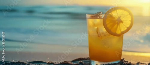Glass of Orange Juice on the Sand with Ocean Waves Background in Summer