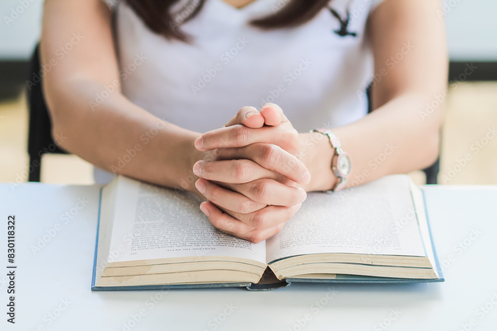 young woman clasped her hands together in prayer asking for forgiveness from God based on her Christian beliefs and faith in God teachings. concept prayer and intercession according beliefs about God young woman clasped her hands together in prayer asking for forgiveness from God based on her Christian beliefs and faith in God teachings. concept prayer and intercession according beliefs about God