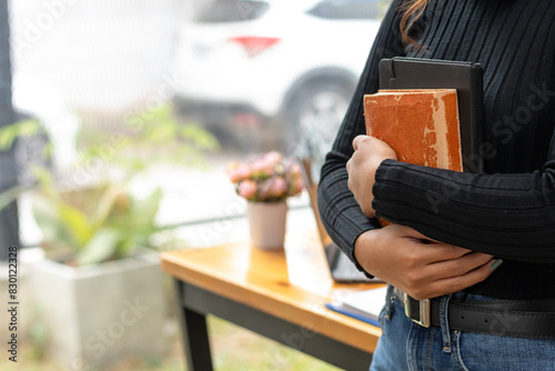 The young woman held a Bible in her hand and tried to learn and understand God teachings from the Bible she held. Concepts of belief and the power of faith in God and teachings from the Bible.