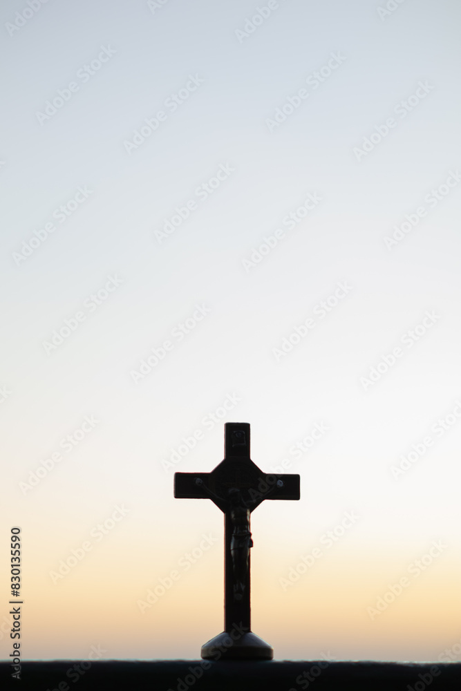 The silhouette of a cross on the background of a twilight sunset is a symbol of God and the cross is also believed to be of His divinity. The cross is a symbol of God loving kindness for all people.