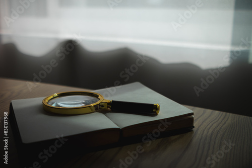 A Bible and a magnifying glass are placed on a wooden table after praying to God Christian religious ritual and belief in the teachings of God. Ideas for praying to God with teachings from the Bible