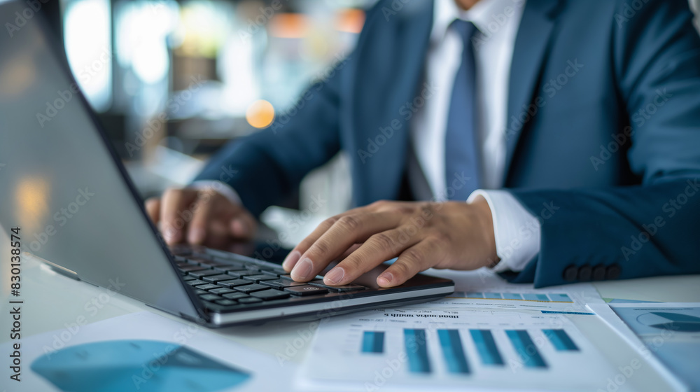 Selective focus on hands of businessman using calculator and laptop and analyzing financial documents preparing financial tax report
