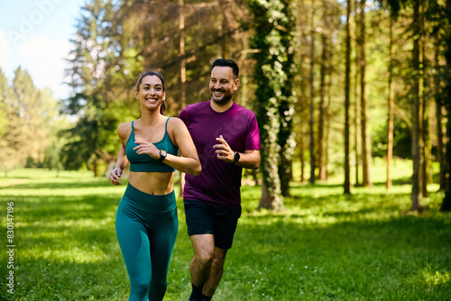 Fototapeta Naklejka Na Ścianę i Meble -  Happy couple of athletes running while exercising in nature.