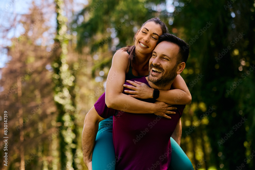 Happy athletic couple piggybacking while working out in park. Happy athletic couple piggybacking while working out in park.