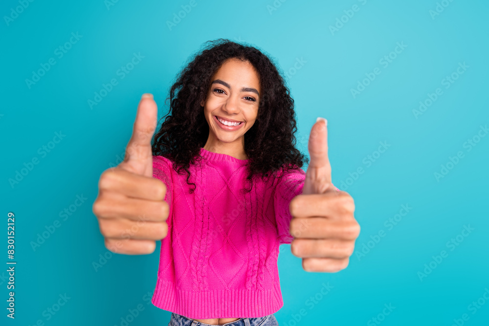 Photo of lovely young girl show thumb up wear pink pullover isolated on teal color background Photo of lovely young girl show thumb up wear pink pullover isolated on teal color background