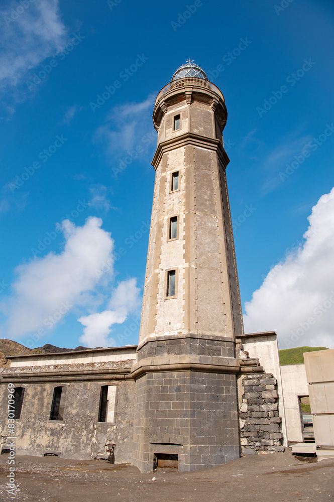 Fototapeta premium Farol da Ponta dos Capelinhos lighthouse at Faial island of the Azores, Portugal. Former beacon on the Atlantic Ocean coast. Eruption of Capelinhos volcano.