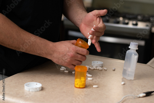 Man desesperated and addicted with many pills and syringes front him in a table