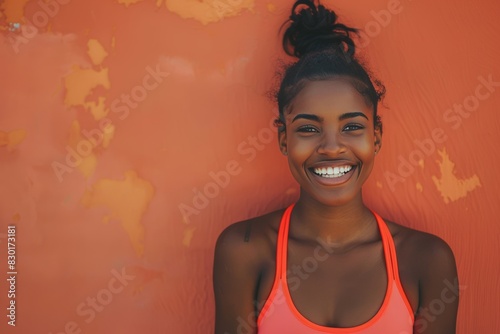 Happy woman in sportswear resting after workout outdoors on colored wall background photo