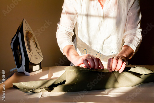 Seamstress Preparing Fabric Next to Scorched Iron