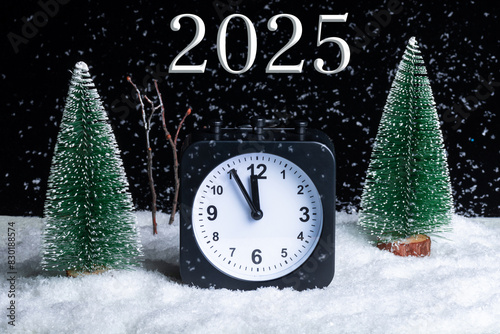 New Year's Eve 2025. Christmas Eve. Composition Night winter forest, blizzard and alarm clock in the snow. Winter time. Christmas holiday time