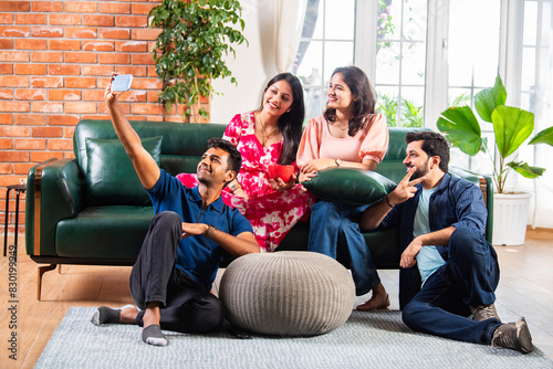 Indian asian young couple taking selfie using smartphone at home photo