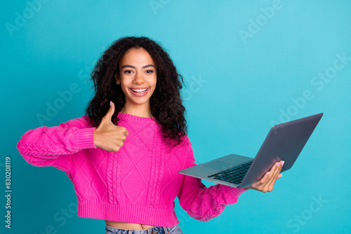 Photo portrait of pretty teen girl hold netbook thumb up wear trendy pink outfit isolated on aquamarine color background © deagreez
