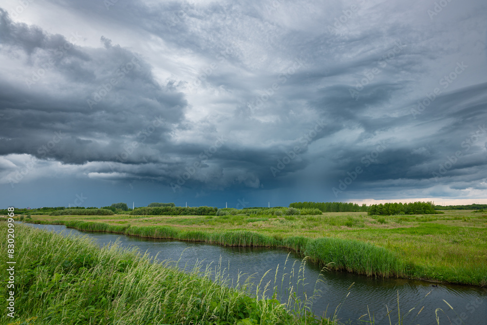 Dramatic looking cloudscape as a thunderstorm passes over the ¨Bentwoud¨ nature reserve in the west of the Netherlands. Dramatic looking cloudscape as a thunderstorm passes over the ¨Bentwoud¨ nature reserve in the west of the Netherlands.