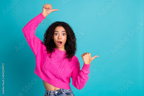 Portrait of nice young girl direct fingers empty space wear pink pullover isolated on turquoise color background