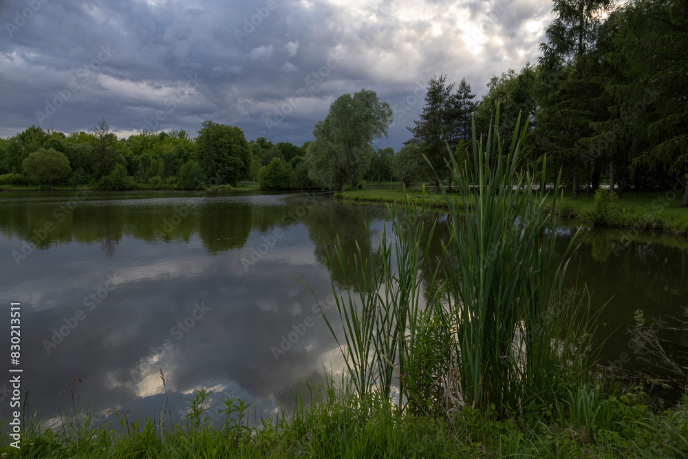 Obraz premium Pond under dramatic skies before nightfall