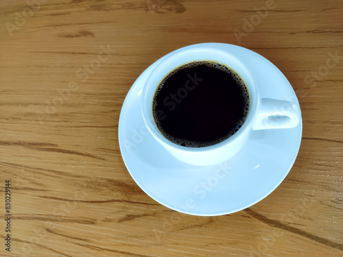 Cup of coffee on the wooden background