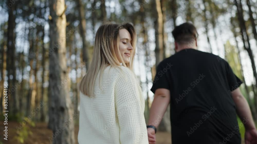 A young man and woman stroll through a sunlit forest, hand-in-hand, sharing a moment of romance and connection amid nature. Young Couple Enjoying a Romantic Walk in a Forest A young man and woman stroll through a sunlit forest, hand-in-hand, sharing a moment of romance and connection amid nature. Young Couple Enjoying a Romantic Walk in a Forest