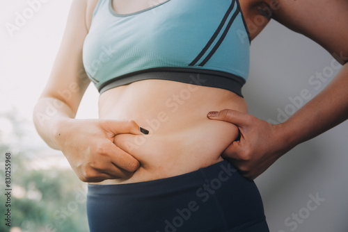 fat woman, fat belly, chubby, obese woman hand holding excessive belly fat with measure tape, woman diet lifestyle concept