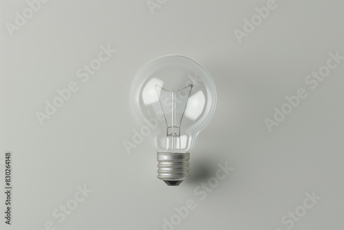 Single incandescent light bulb is centered against a clean, neutral background, symbolizing ideas, innovation, and simplicity in this minimalist composition