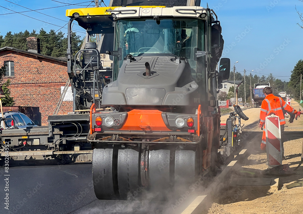 Construction of a new street surface. Laying a layer of asphalt with a specialized machine Construction of a new street surface. Laying a layer of asphalt with a specialized machine
