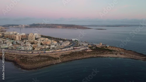 Qawra cityscape in the early morning, during the sunset. Revealing Qawra tower , and Malta National Aquarium. Aeral shot. High quality 4k footage photo