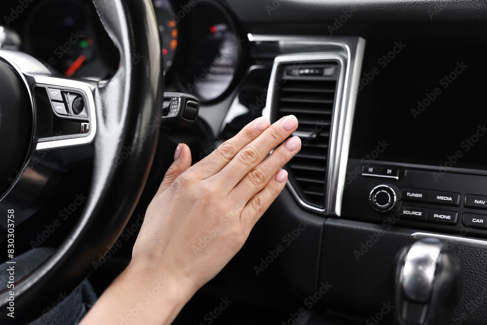 Woman checking air conditioner in her car, closeup Woman checking air conditioner in her car, closeup