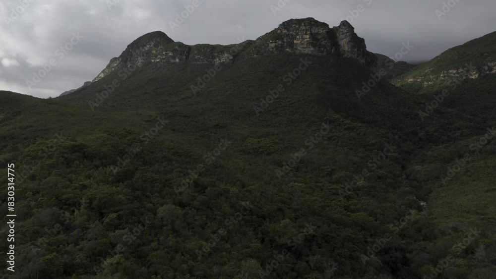 Drone flies over forest toward top of mountain range on overcast day Drone flies over forest toward top of mountain range on overcast day