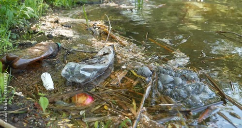 Garbage lies on lake shore, pollution of environment. Plastic must be recycled