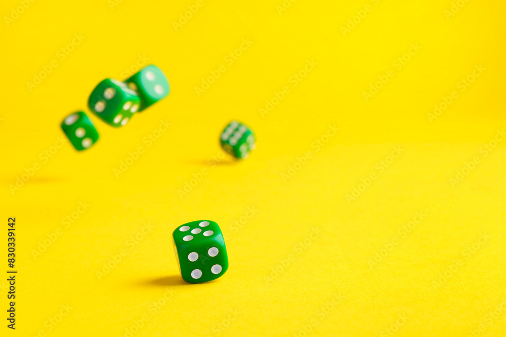 Many green game dices falling on yellow background. Space for text Many green game dices falling on yellow background. Space for text