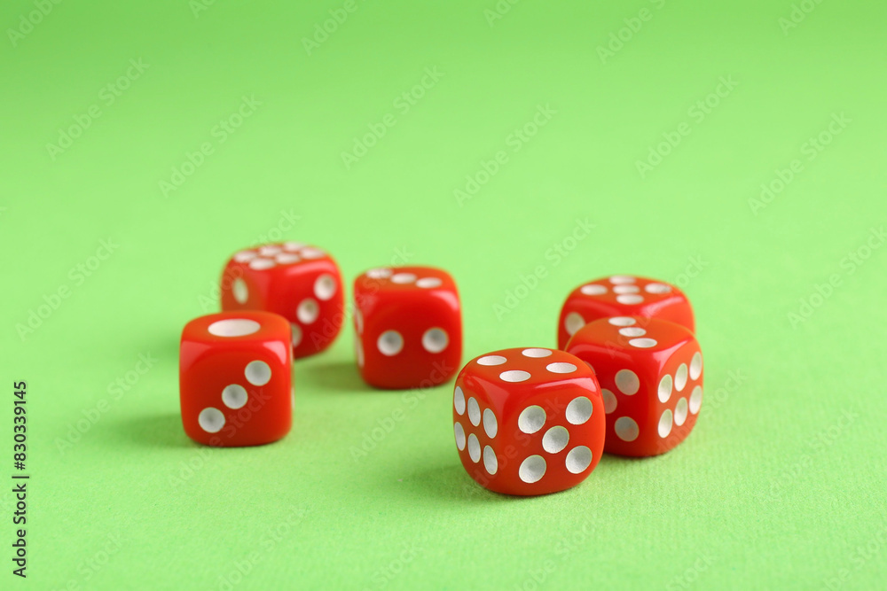 Many red game dices on green background Many red game dices on green background