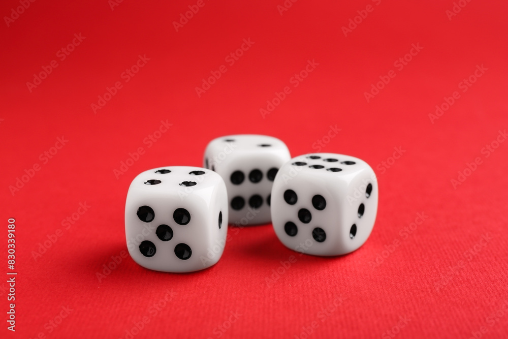 Three white game dices on red background, closeup Three white game dices on red background, closeup
