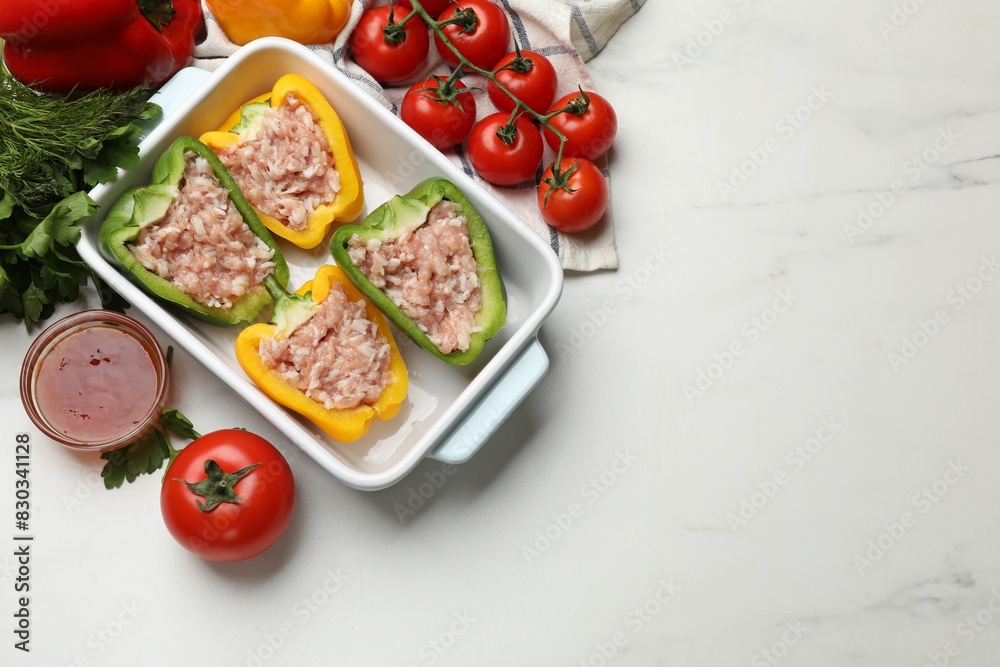 Raw stuffed peppers and ingredients on white table, flat lay. Space for text