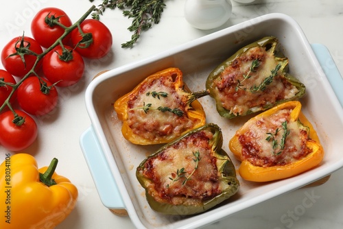 Tasty stuffed peppers in dish and ingredients on white table, flat lay © New Africa