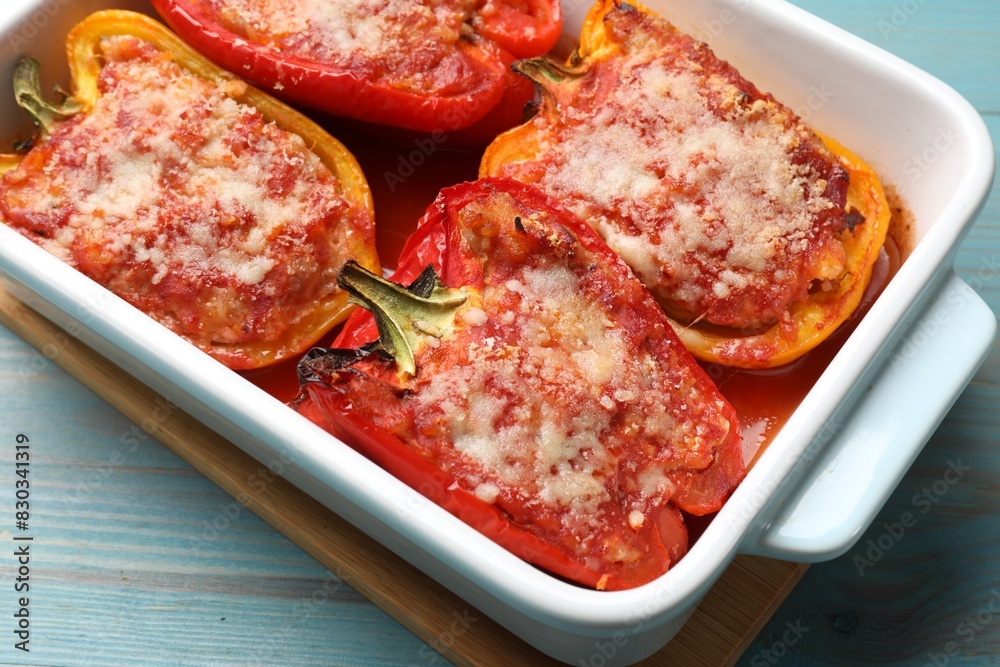 Tasty stuffed peppers in dish on light blue wooden table, closeup Tasty stuffed peppers in dish on light blue wooden table, closeup