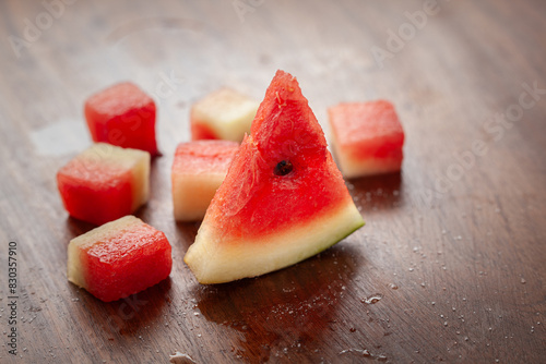 Close-up of watermelon Slice and Cubes (Citrullus Lanatus), on a wooden background. photo