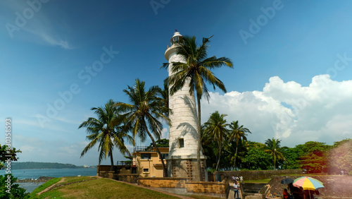 Galle Lighthouse at Galle Fort, Sri Lanka. Action. Beautiful palm trees and blue cloudy sky.