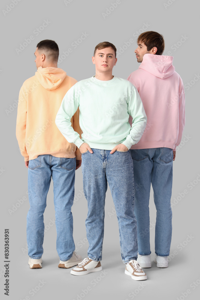 Young men in stylish jeans on light background Young men in stylish jeans on light background