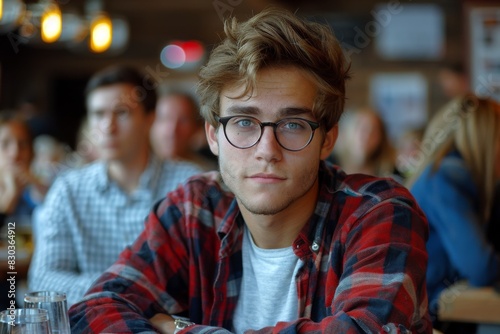 Young man in glasses and plaid shirt at casual gathering