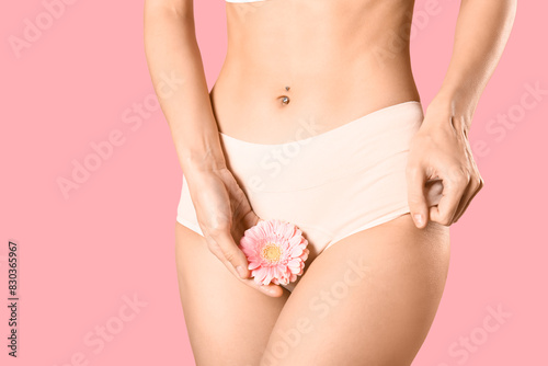 Young woman in panties with beautiful flower on pink background © Pixel-Shot