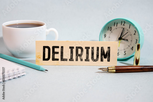 word delirium made of wooden letters on a gray table on a green background.