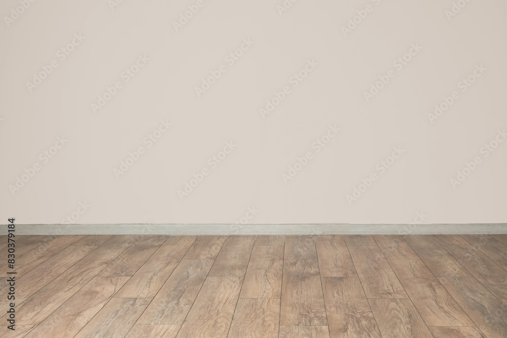 View of light wall and new wooden laminate in empty room View of light wall and new wooden laminate in empty room